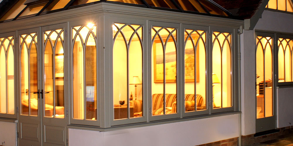 A warm Malbrook Conservatory from outside at night.